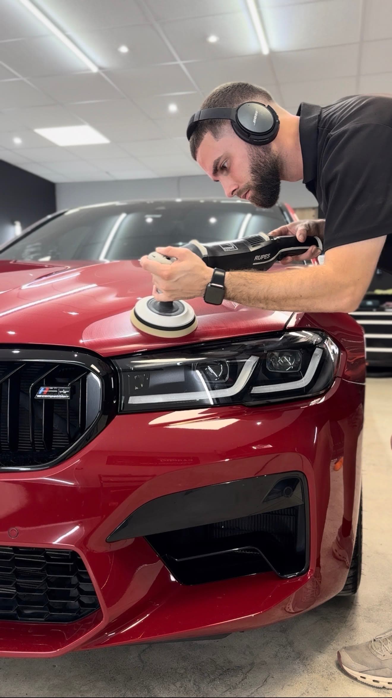 Emilio puliendo un BMW M5 rojo en el estudio de RB Car Care