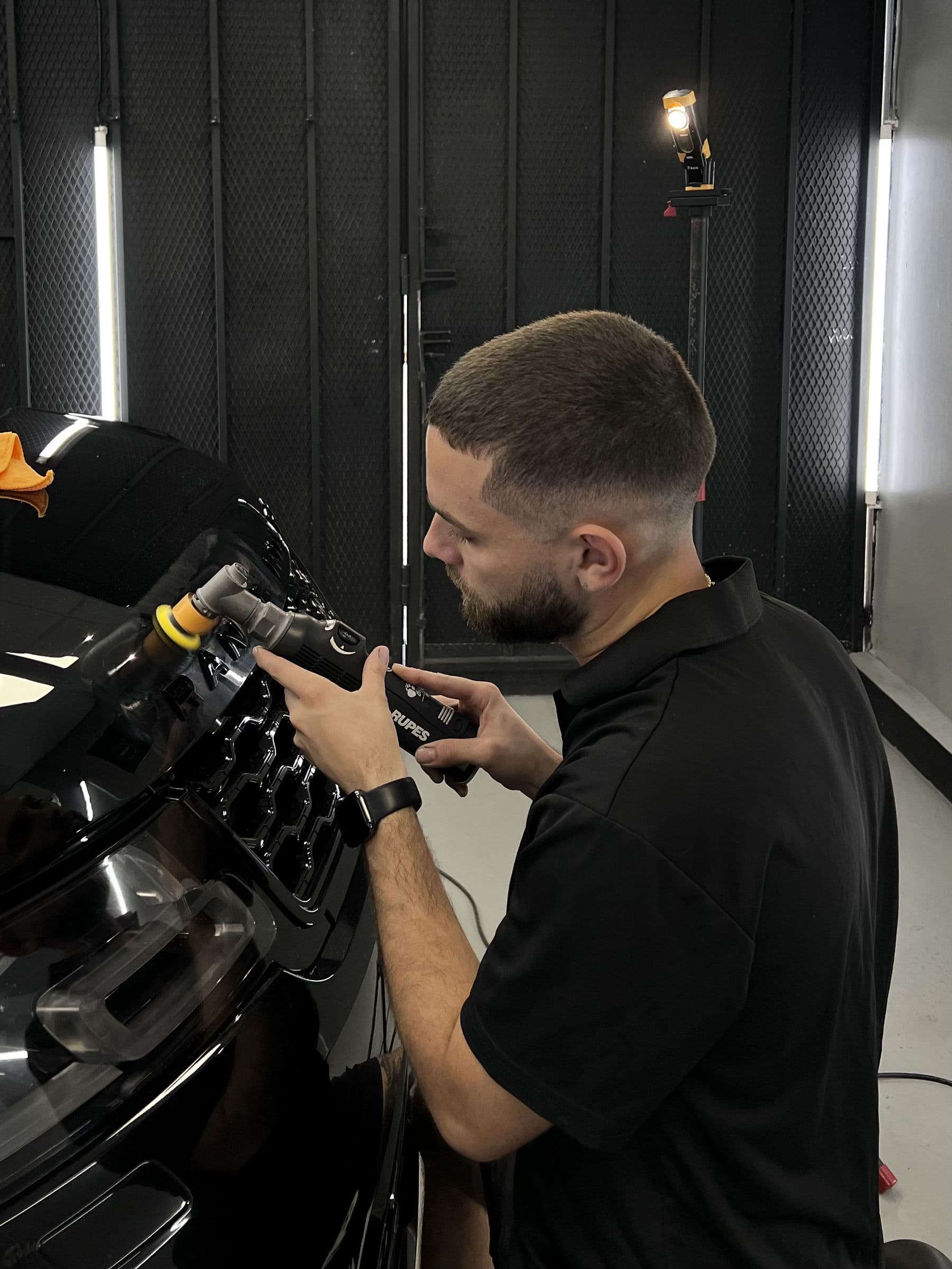 Técnico puliendo el bonete de un Range Rover